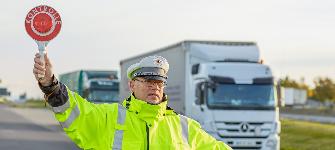 
Ein Mitarbeiter des BALM hält Fahrzeuge mit einer roten Kelle an, um eine Kontrolle durchzuführen