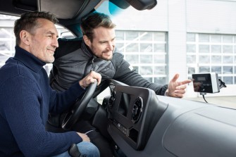 
Ein Servicepartner erklärt einem Lkw-Fahrer die Bedienung der Windshield OBU