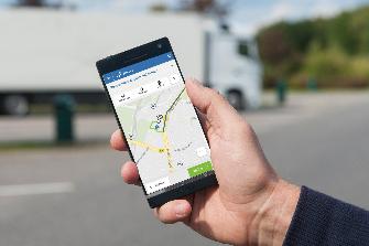 
Eine Hand hält ein Smartphone, der Bildschirm zeigt die Toll Collect-App.