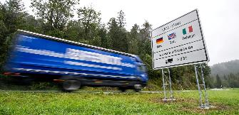 
Ein Lkw-Fahrer fährt an einem Maut-Schild vorbei.